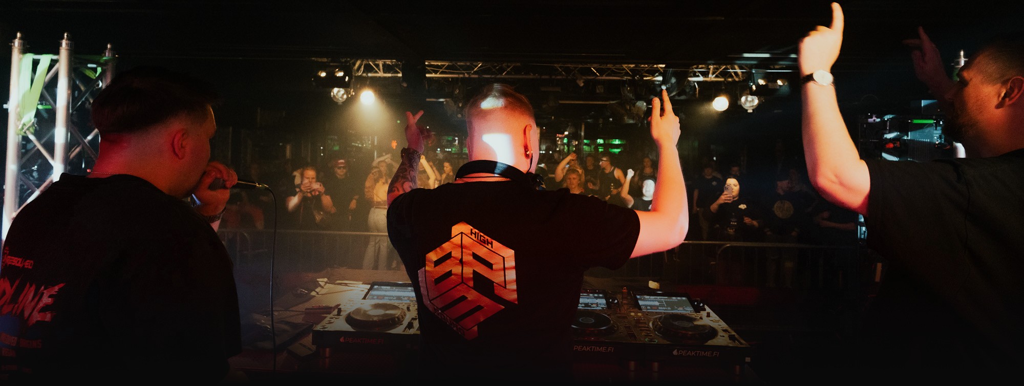 Live show: DJ behind the decks in a High BPM Squad shirt, crowd with hands in the air